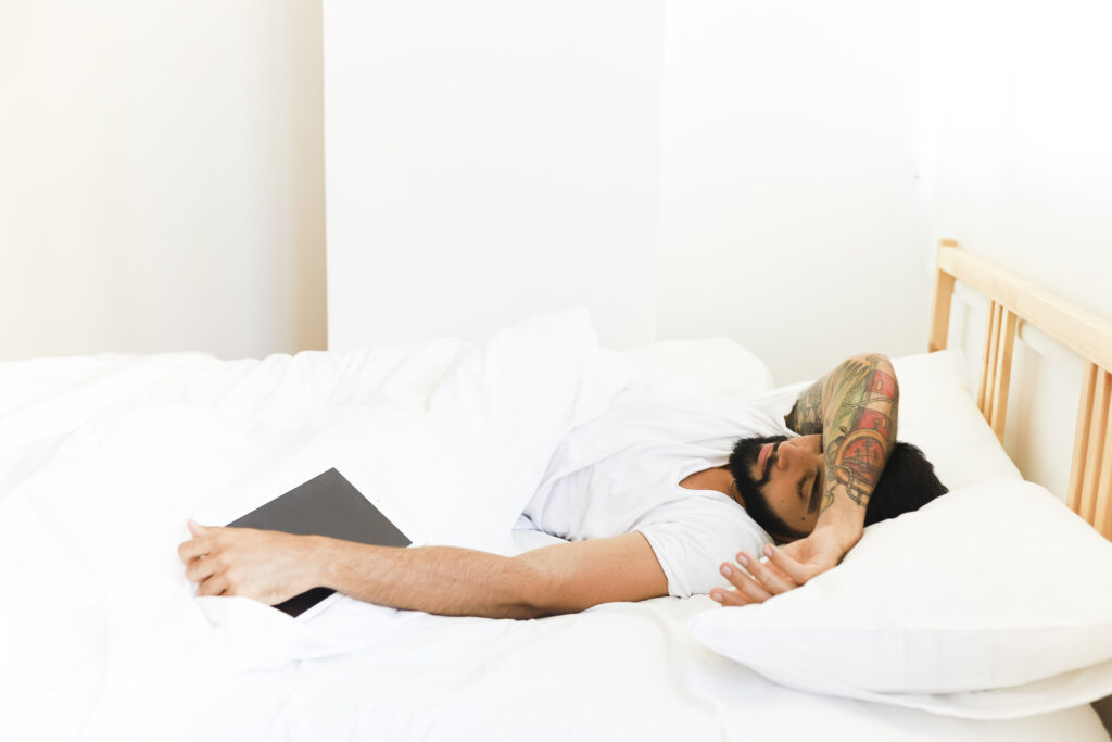 young-man-sleeping-bed-with-digital-tablet